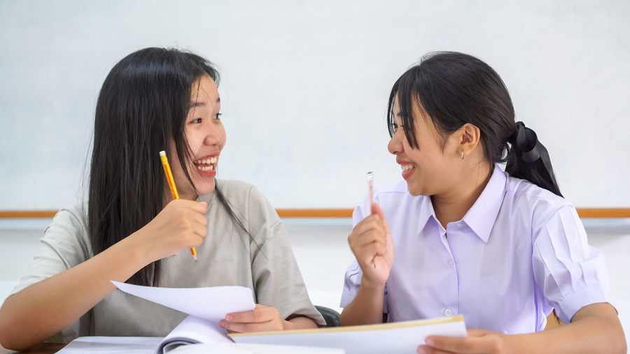 Two students discussing during class at maths tuition centre